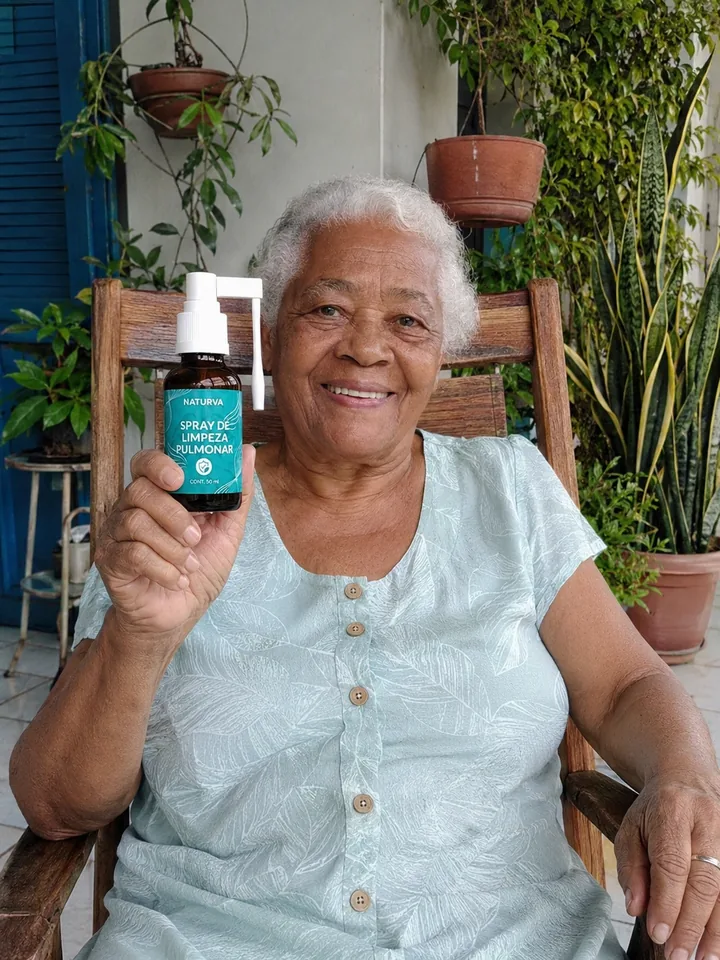 Cliente na cadeira da varanda segurando o frasco do Naturva™ Spray de Limpeza Pulmonar